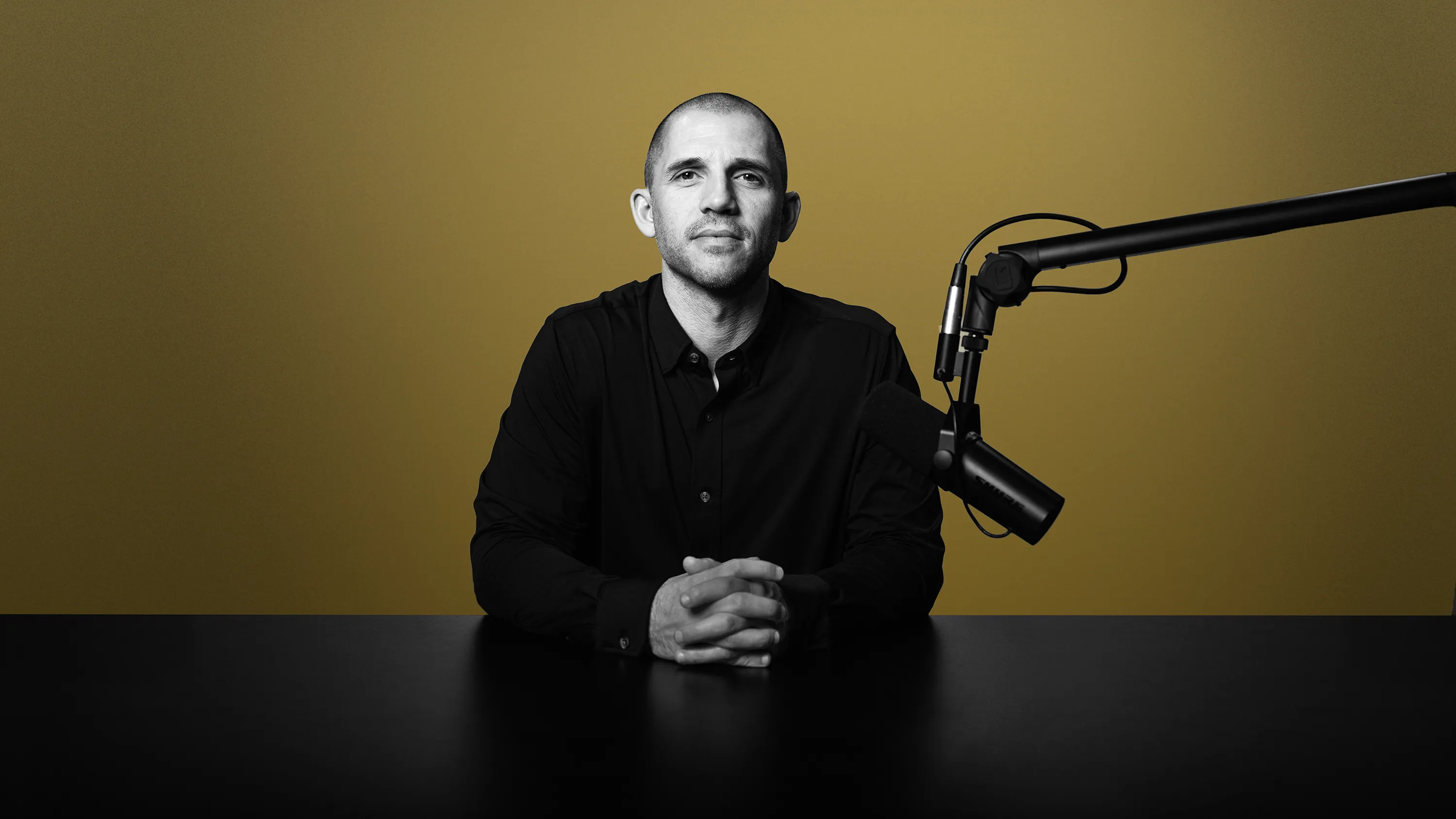 Dr. Andy Galpin seated at a desk with a podcast microphone